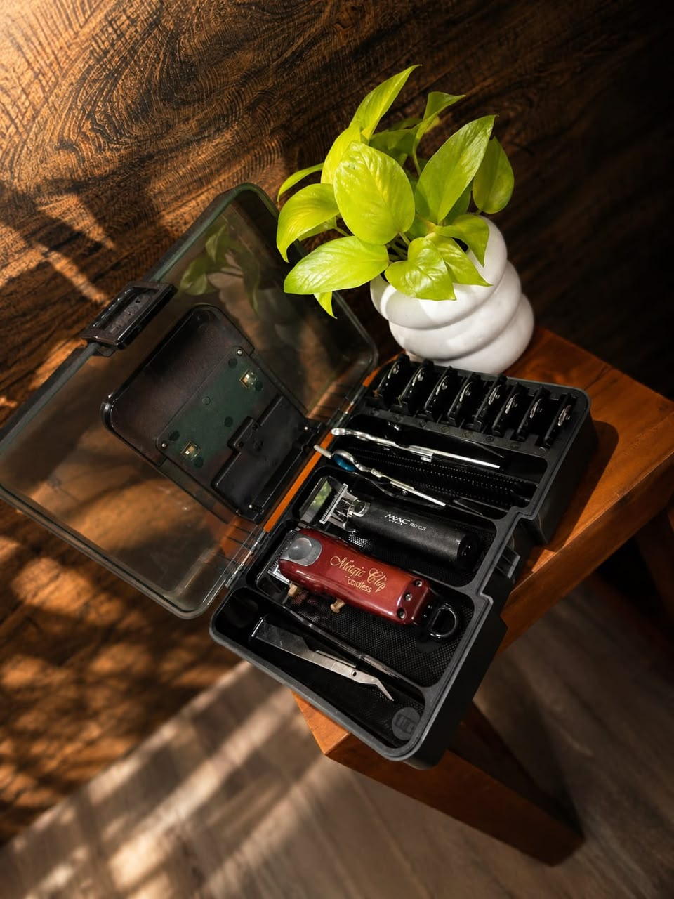 Professional barber tools arranged beside a plant